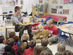 Kids sitting on a class room paying attention to their teacher.